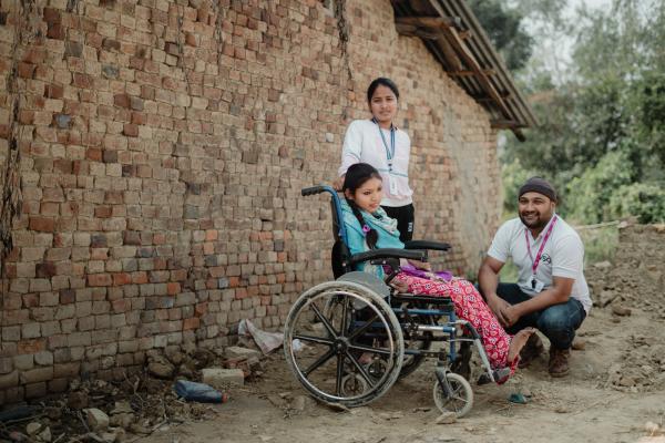 Volunteers with girl in wheelchair