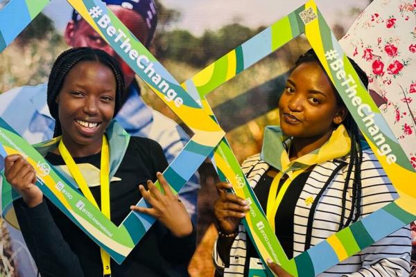 Women pose at the #BeTheChange photobooth