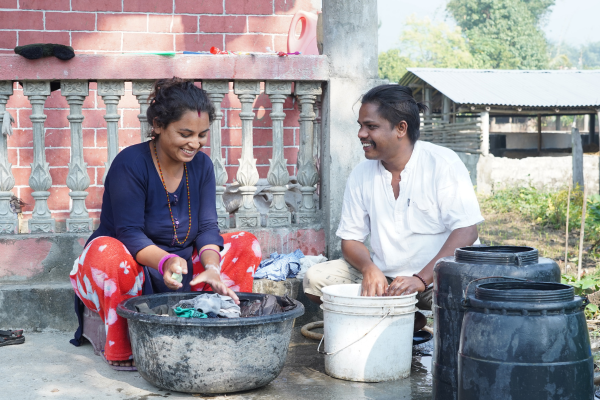 Woman and her husband wash dishes