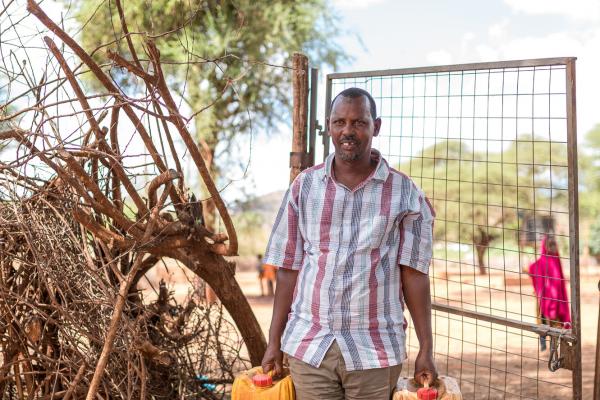 Man carrying jerrycans for water 